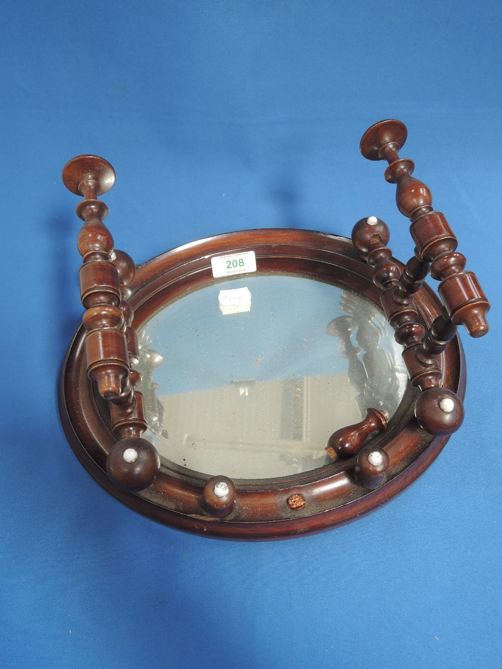 A 19th century mahogany oval mirror wool winder barcket