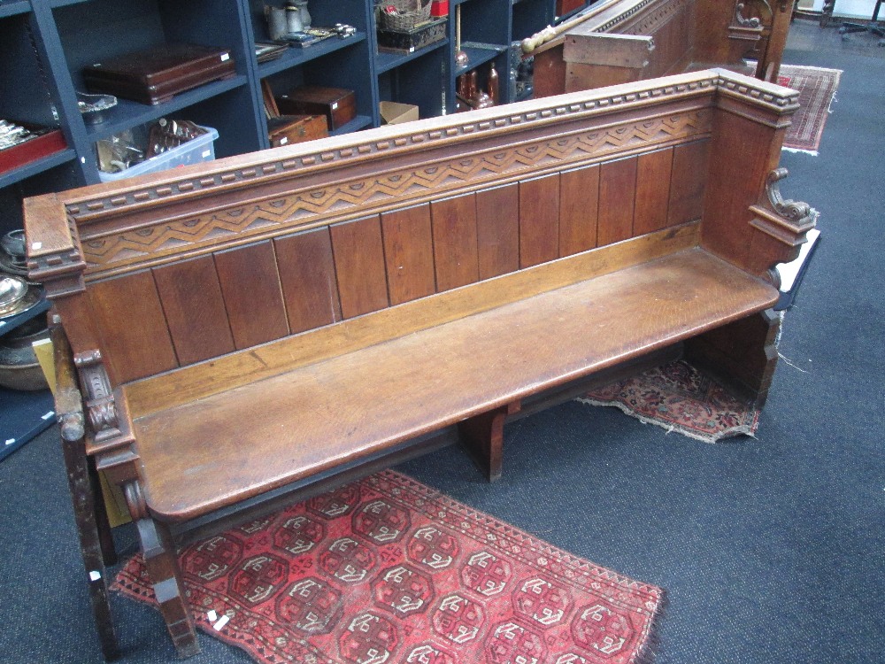 A late Victorian oak pew having carved decoration