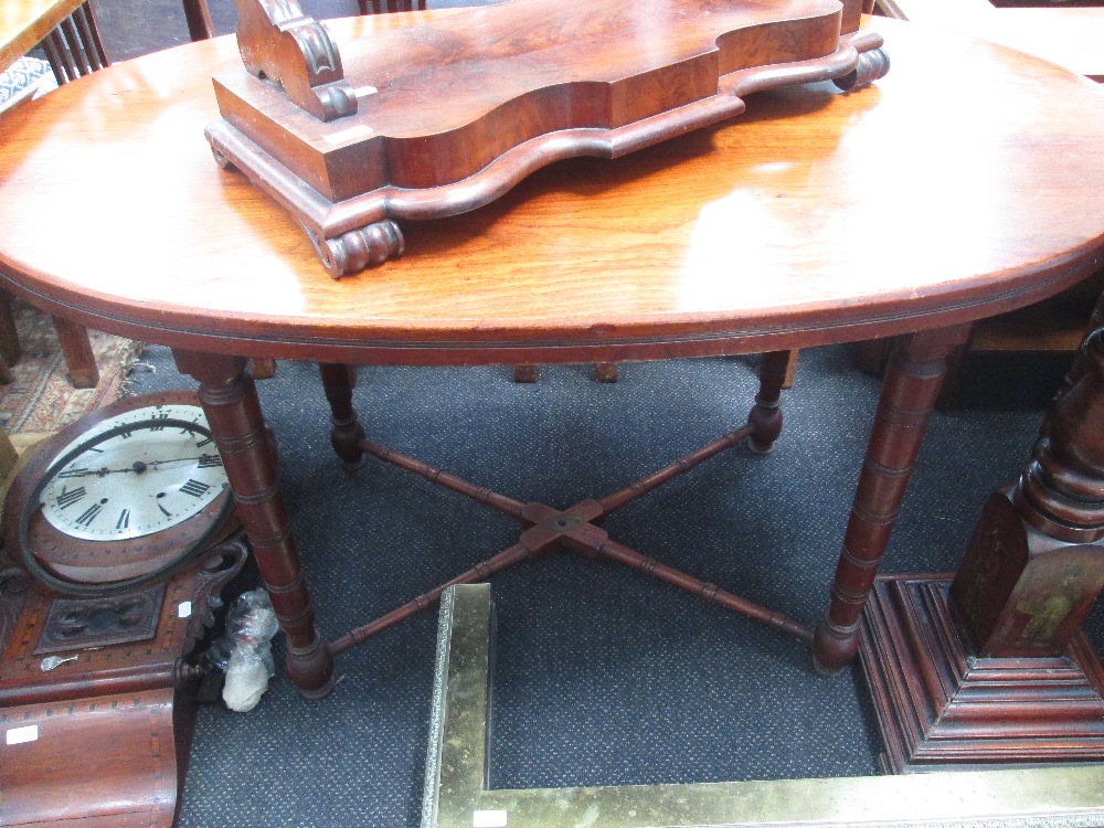 An early 20th century part mahogany ships dining table having oval top, ring turned legs and cross