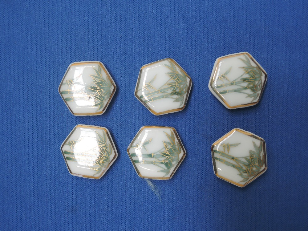 A set of six ceramic octagonal buttons having Oriental decoration