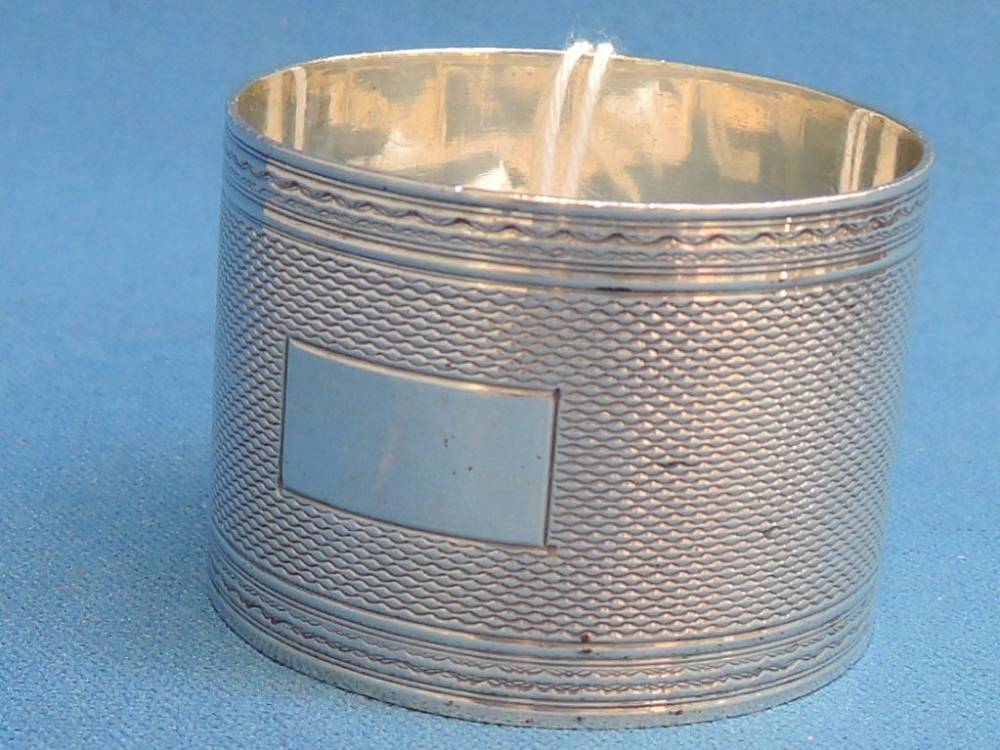A silver napkin ring having engine turned decoration and plain cartouche, Birmingham 1922, possibly
