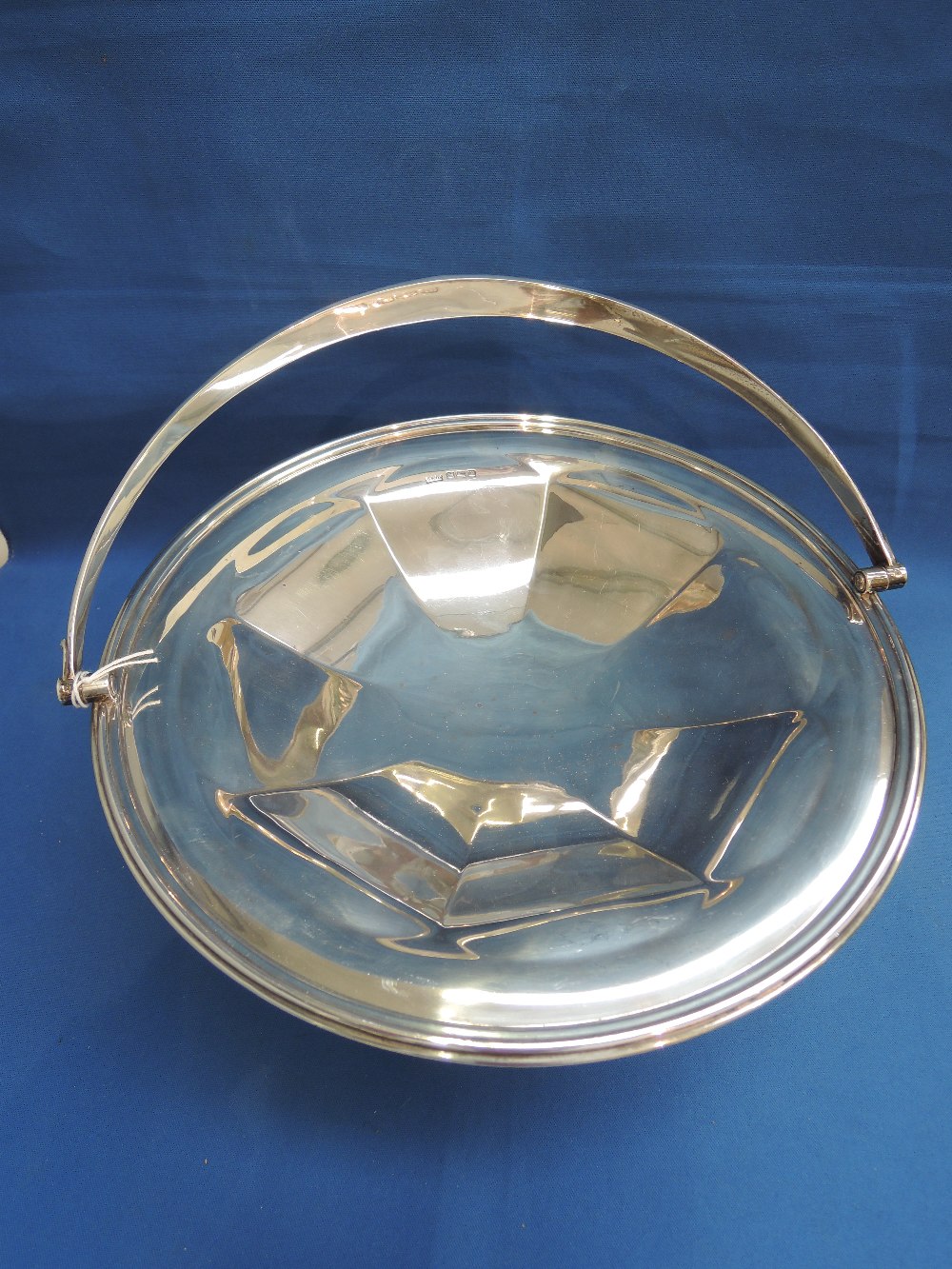 A silver basket of plain circular form on a raised octagonal column foot, Sheffield 1929, makers