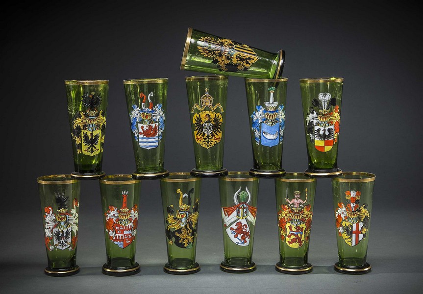 TWELVE BOHEMIAN ENAMELED AND PARCEL-GILT GREEN GLASS PILSNER VESSELSEarly 20th centuryEach painted