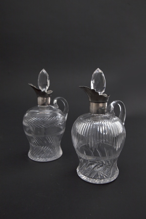 A PAIR OF SILVER MOUNTED CUT GLASS CLARET JUGS, London 1905, each with facet-cut oval stoppers,