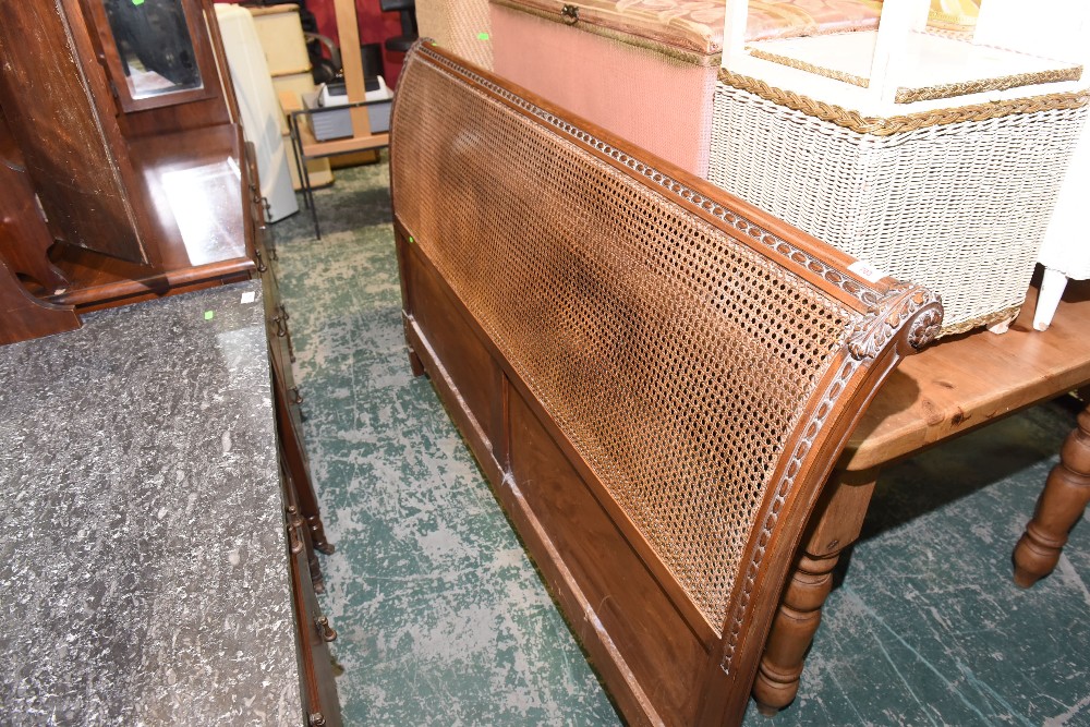 An early 20th century oak canework headboard
