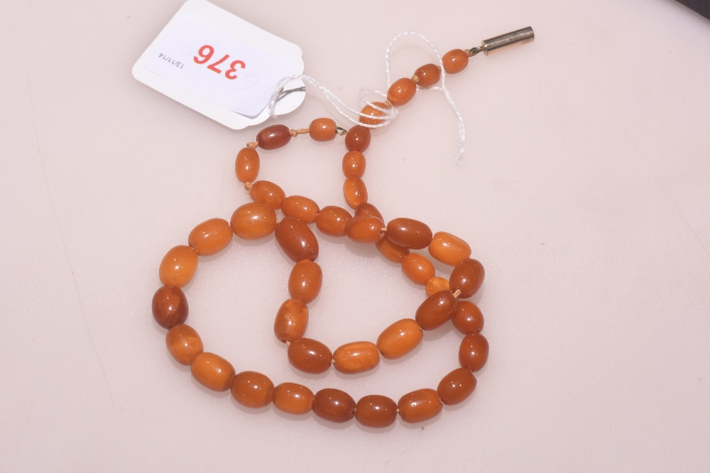 A bead necklace, probably amber, of graduated oval beads (clasp damaged). Length 45cm, weight 17.5