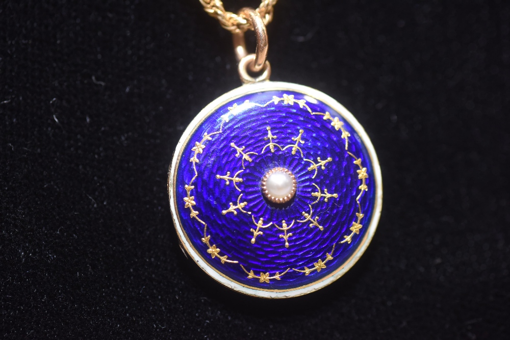 An early 20th century blue guilloche enamel locket, mounted in 15ct gold, of circular form, the