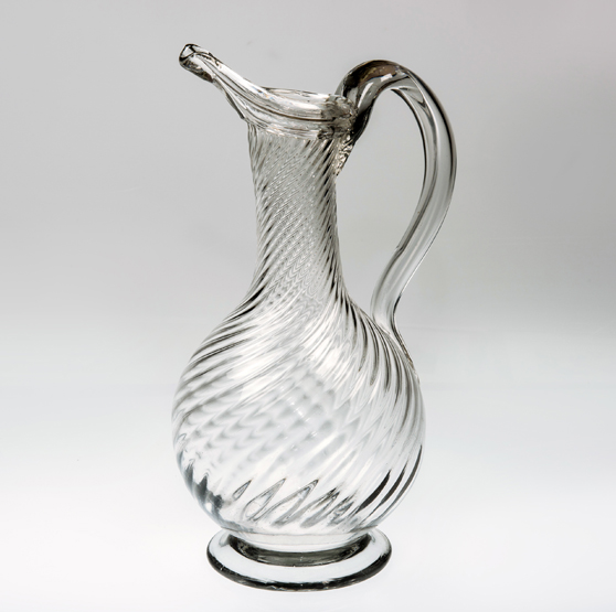 AN 18th CENTURY GLASS EWER, the wrythen baluster body with loop handle, elongated spout and raised