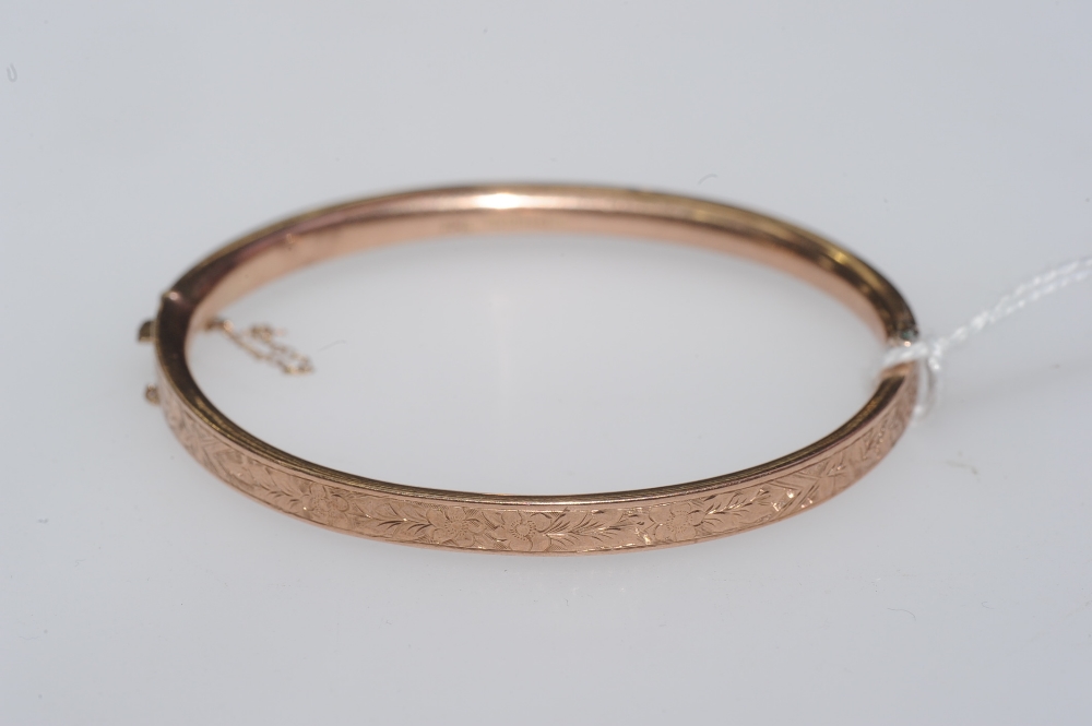 A 9ct gold engraved bangle. 6 grams