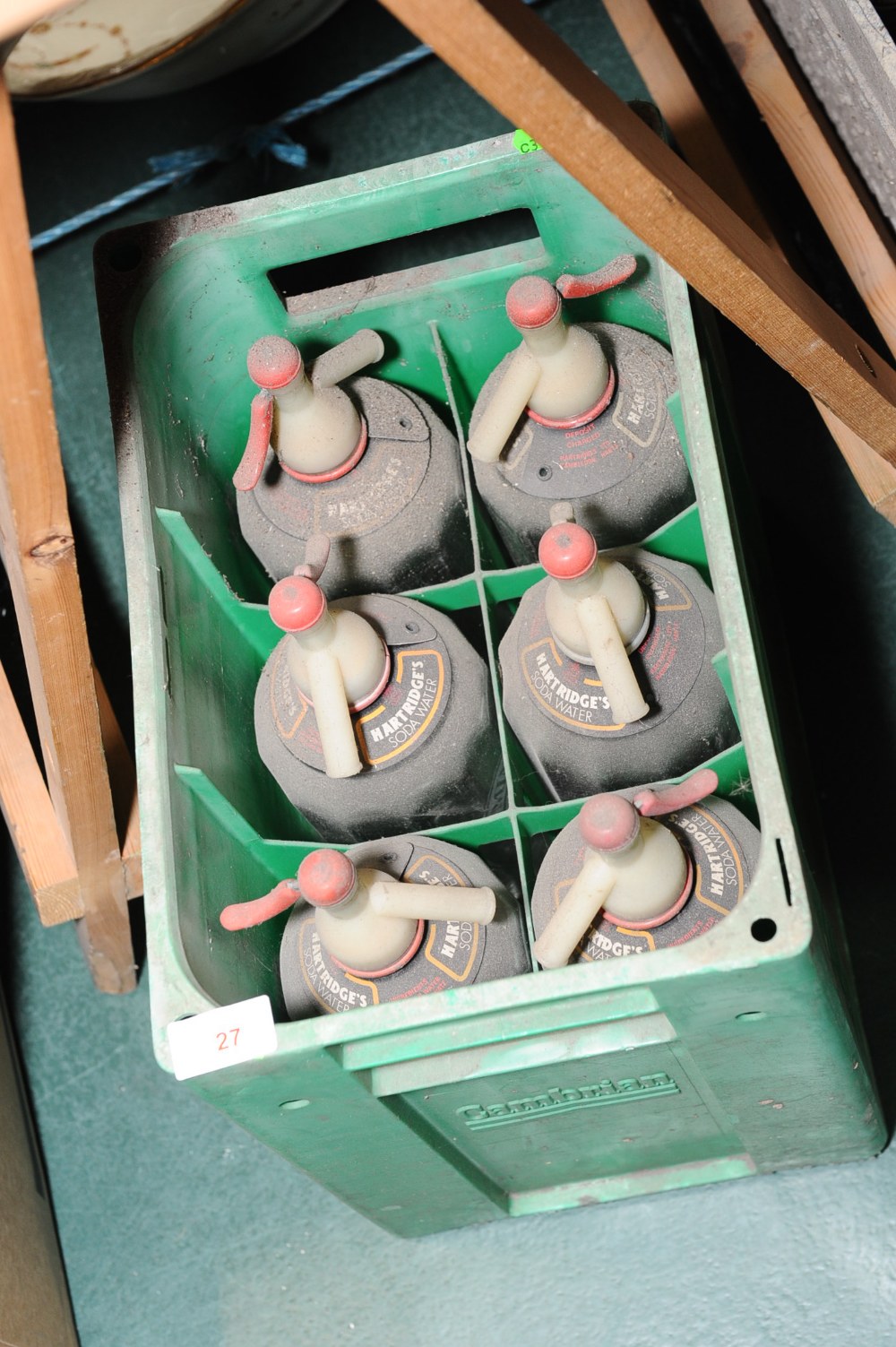 Six vintage soda syphons in a plastic case