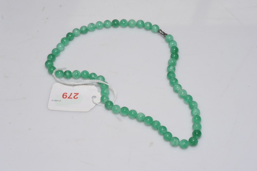 A jadeite bead necklace, the single strand of uniform beads on a white metal clasp. Length 45mm,