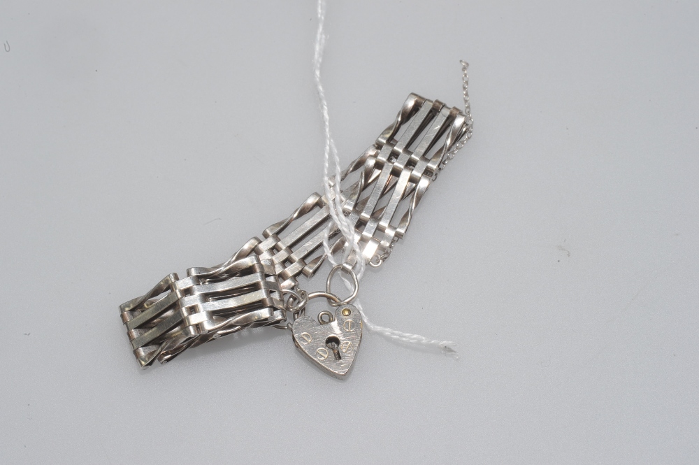 A silver gatelink bracelet, with heart padlock clasp.