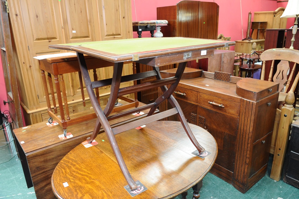 An early 20th century mahogany x-frame foldover card table