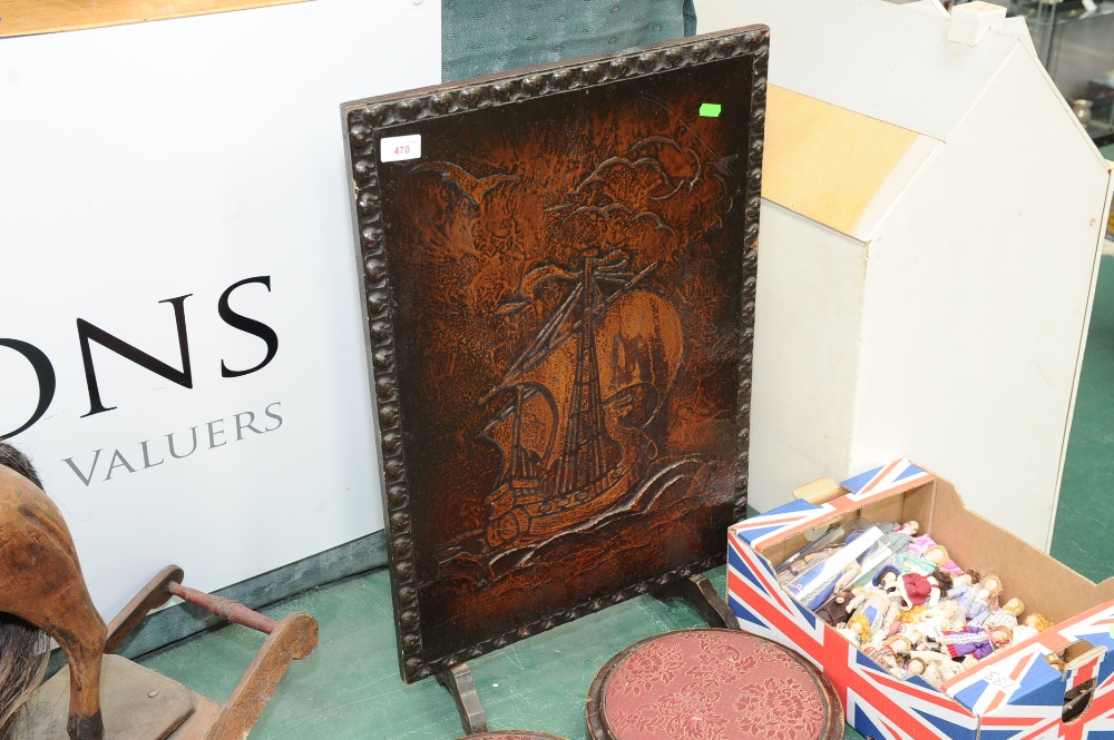 A vintage stamped leather firescreen