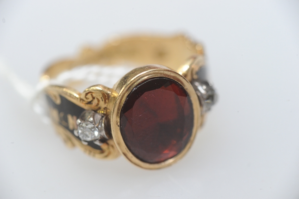 A mid-Victorian 18ct gold, diamond, garnet and enamel mourning ring, the oval-cut garnet between a
