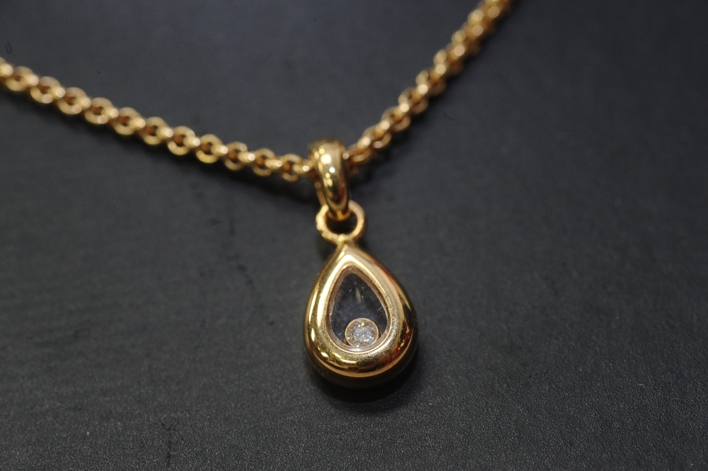 Chopard: an 18ct gold and diamond pendant, the loose round brilliant-cut stone within a glazed