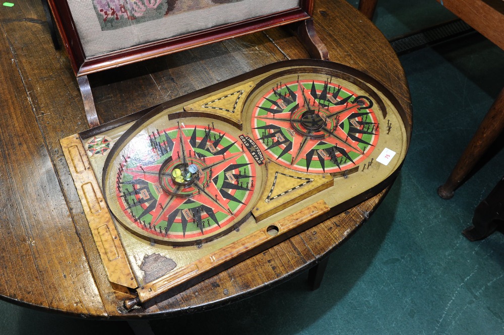 A 1930`s painted tin-plate bagatelle board Lindstrom`s "Gold Star", with two marbles.