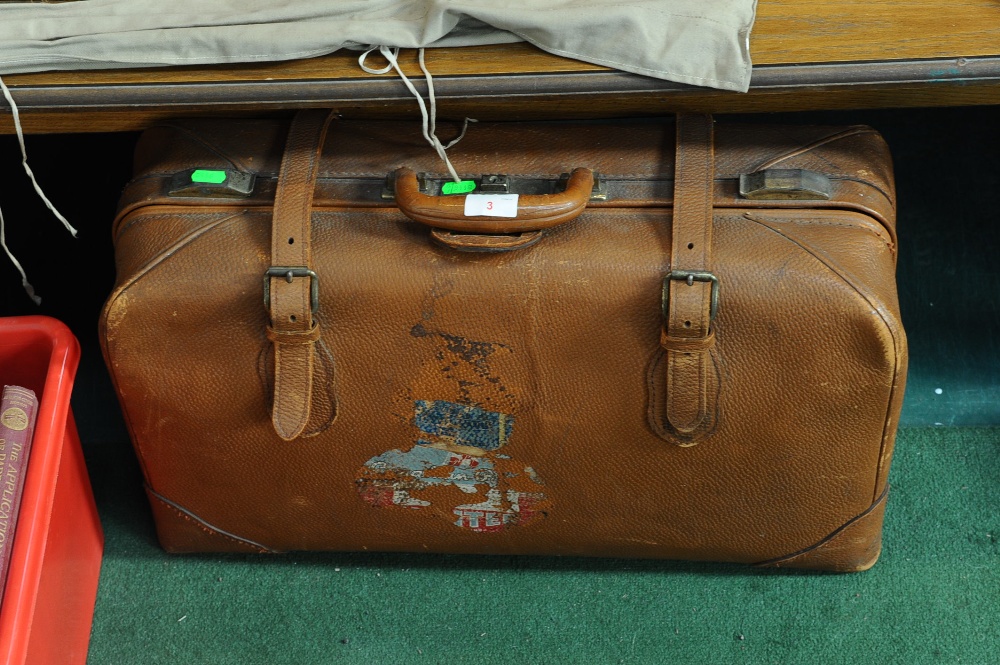 A vintage leather suitcase with paper labels