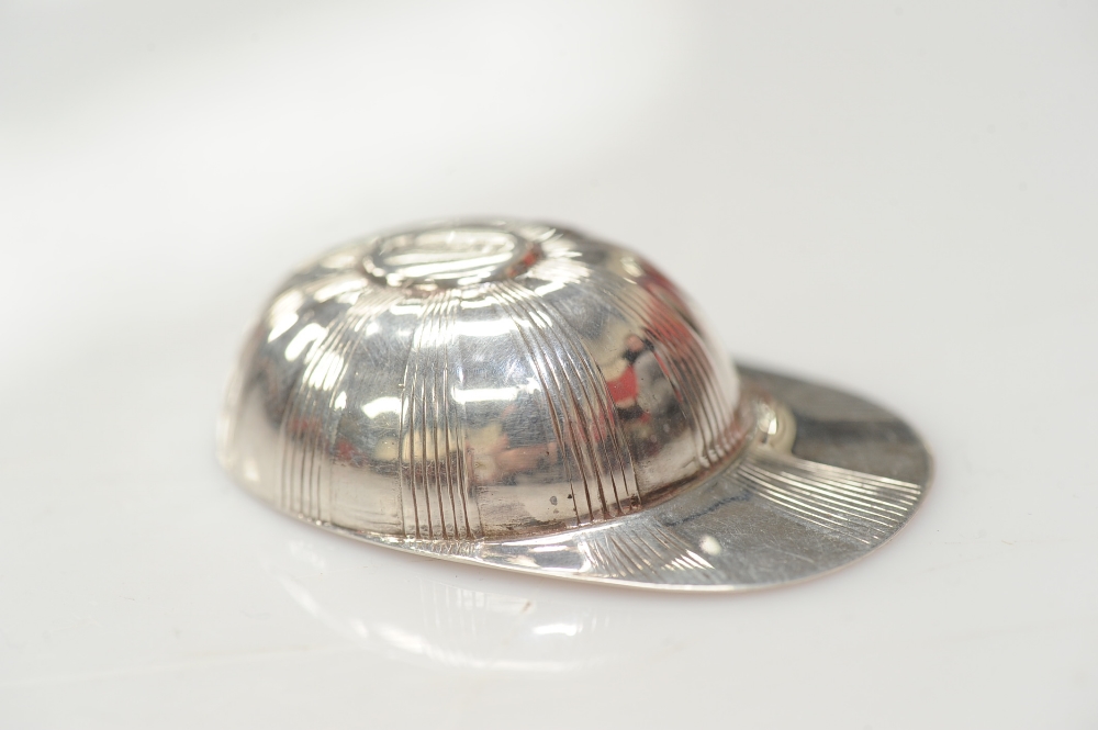 A novelty silver caddy spoon in the form of a jockey`s cap, London 1990, 0.3 troy ounce.