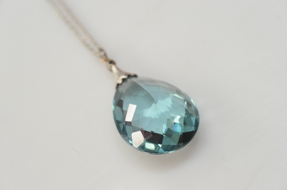 An aquamarine and diamond pendant, circa 1900, the pear shaped faceted aquamarine drop weighing 29.