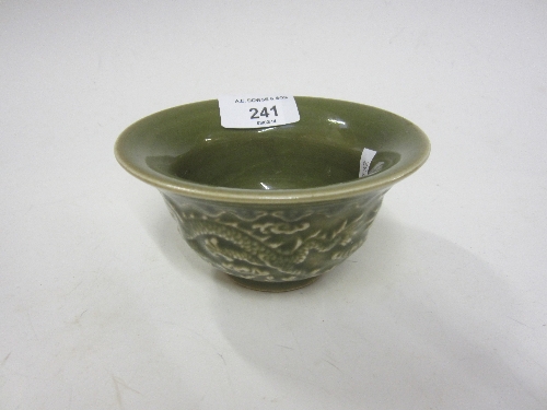 A CHINESE CELADON CIRCULAR BOWL, olive coloured glaze, moulded decoration of dragons chasing a