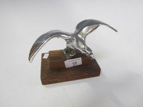 A CHROME CAR MASCOT, modelled as a bird in flight, wooden plinth, width 20cm. fn: From an Alvis.