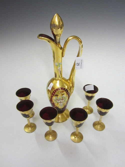 A BOHEMIAN GOLD OVERLAID RUBY GLASS LIQUEUR EWER, floral decoration, 33cm. and six matching