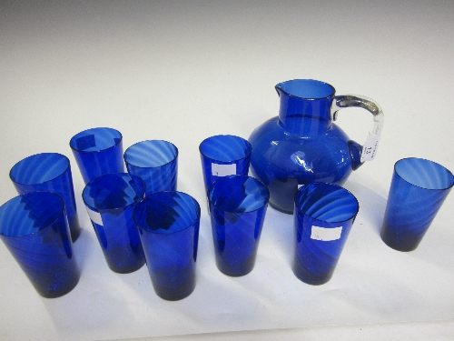 A BLUE GLASS JUG, 19cm. and ten blue glass beakers. (11)