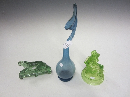 A LIME GREEN TINTED PRESSED GLASS BOOKEND, Judy, seated, 18cm. and a green pressed glass model of