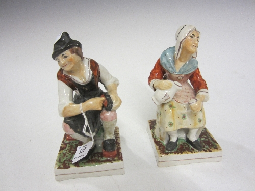 A PAIR OF STAFFORDSHIRE OLD AGE FIGURES, modelled as The Cobbler and his Wife, painted in colours,