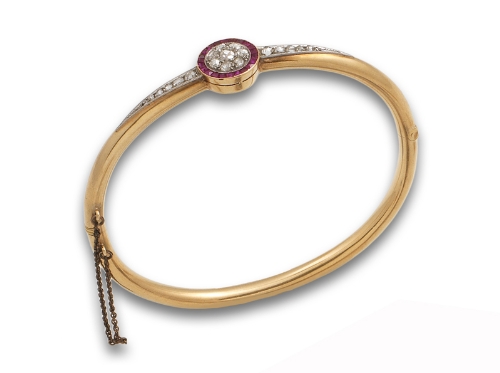 Brazalete rígido de pp s. XX con rosetón central de  diamantes y orla de rubíes calibrados. El