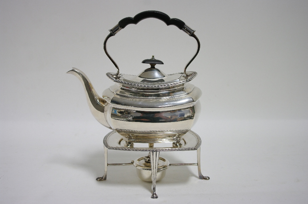 A GEORGE V TEA KETTLE of shaped oblong form, with gadrooned border, hinged lid, over-hang handle, &