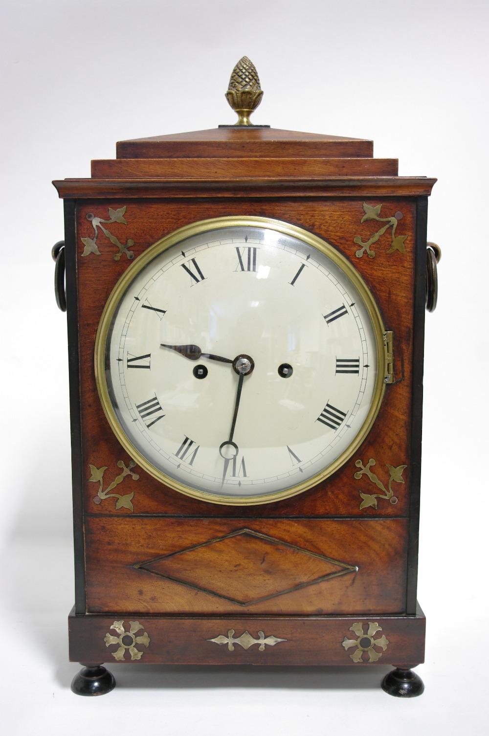 A REGENCY BRACKET CLOCK in brass-inlaid mahogany case with brass cone finial to the stepped