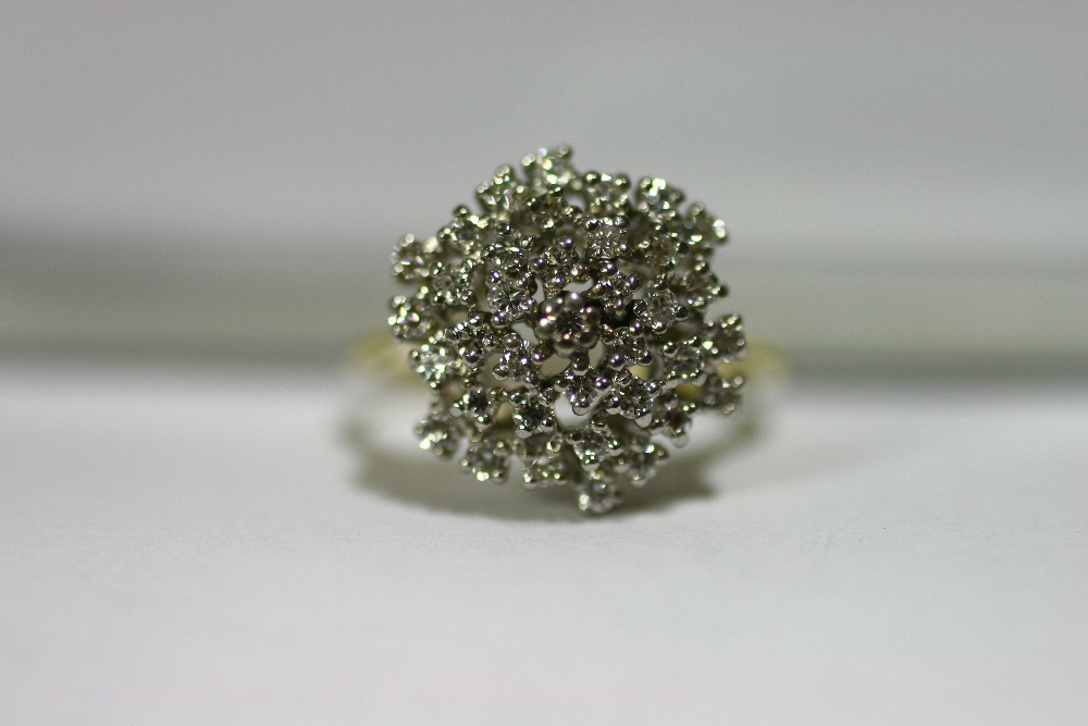 A diamond cluster ring set numerous small stones to a yellow metal shank marked ?18K?.