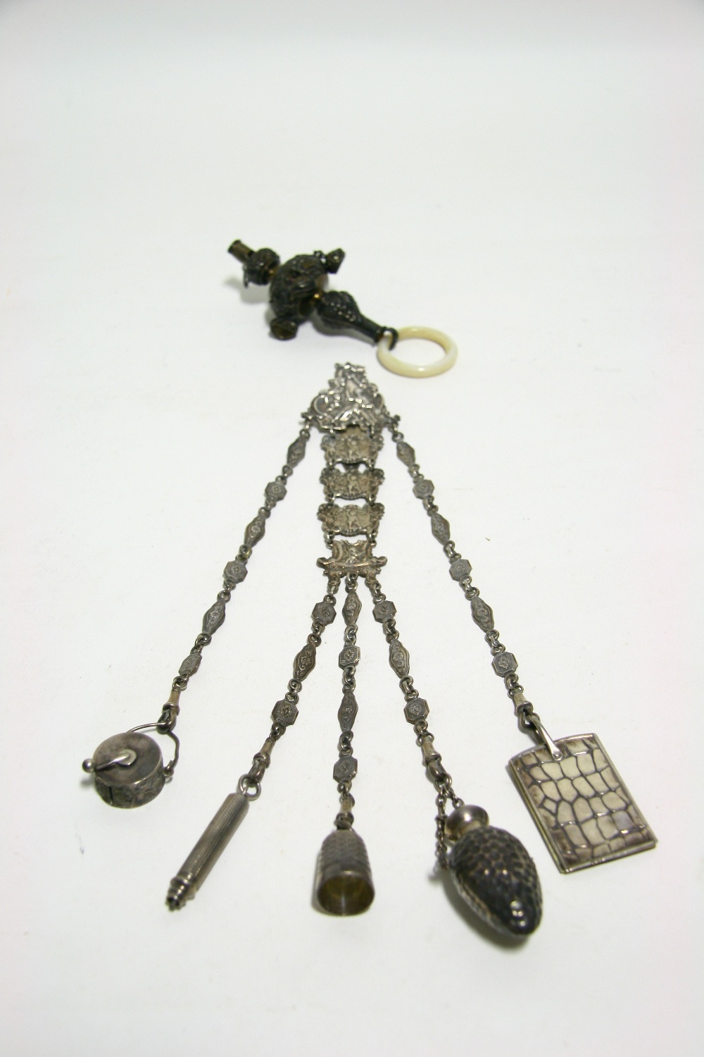 An Edwardian chatelaine with hinged belt hasp, the articulated panels decorated with mythological
