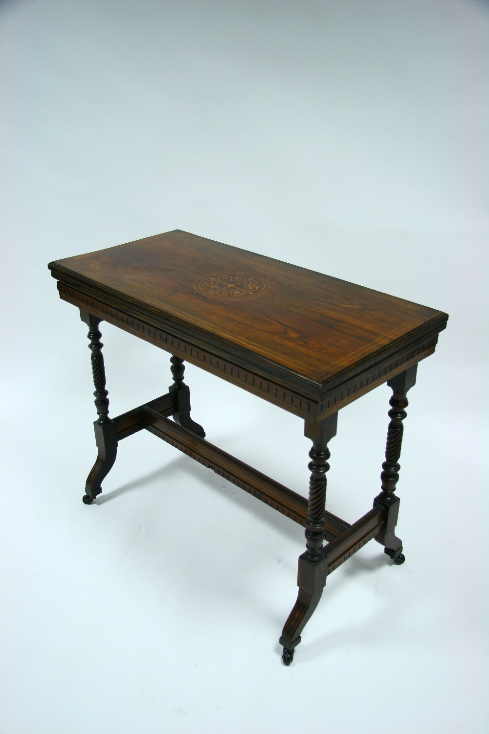 A Victorian rosewood & simulated rosewood card table with marquetry roundel to the rectangular