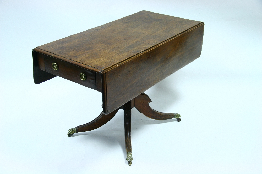 A regency mahogany Pembroke table on turned centre column & four splay legs with cast brass