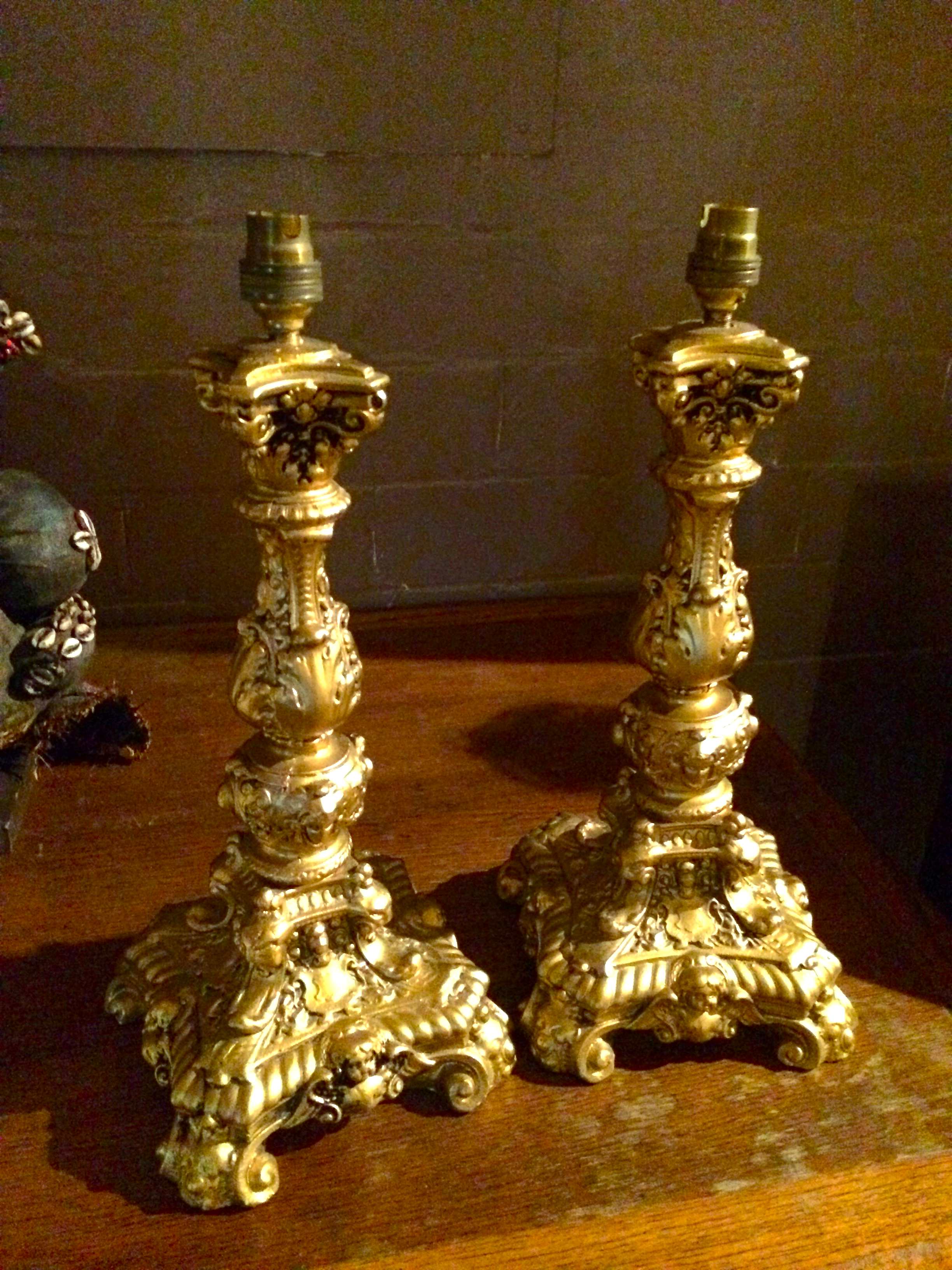 A pair of heavy resin candlestick style lamps of neo-rococo influence.