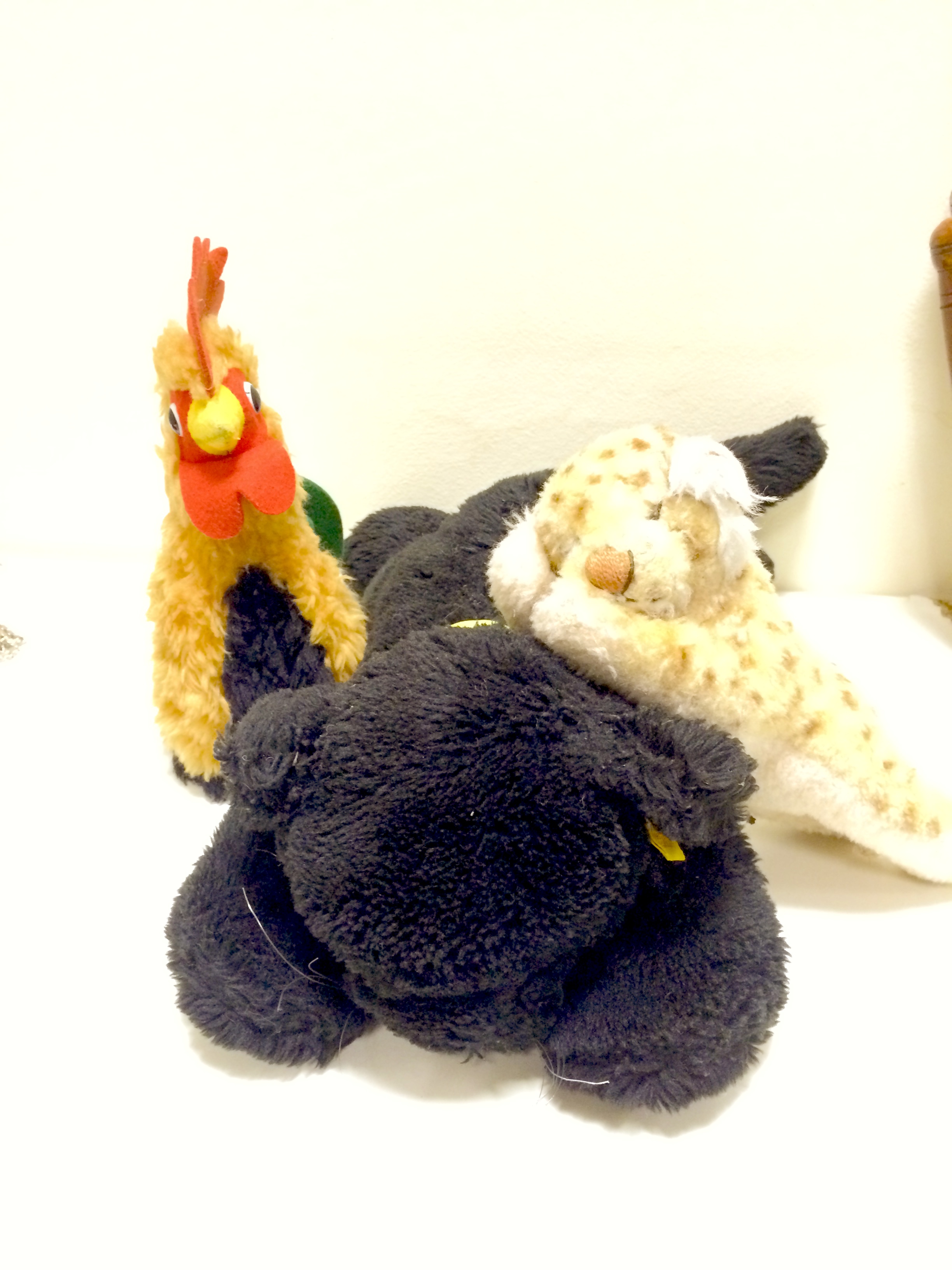 A Steiff black cat with button and label, along with a stiff cockerel, no button and a Steiff cub -