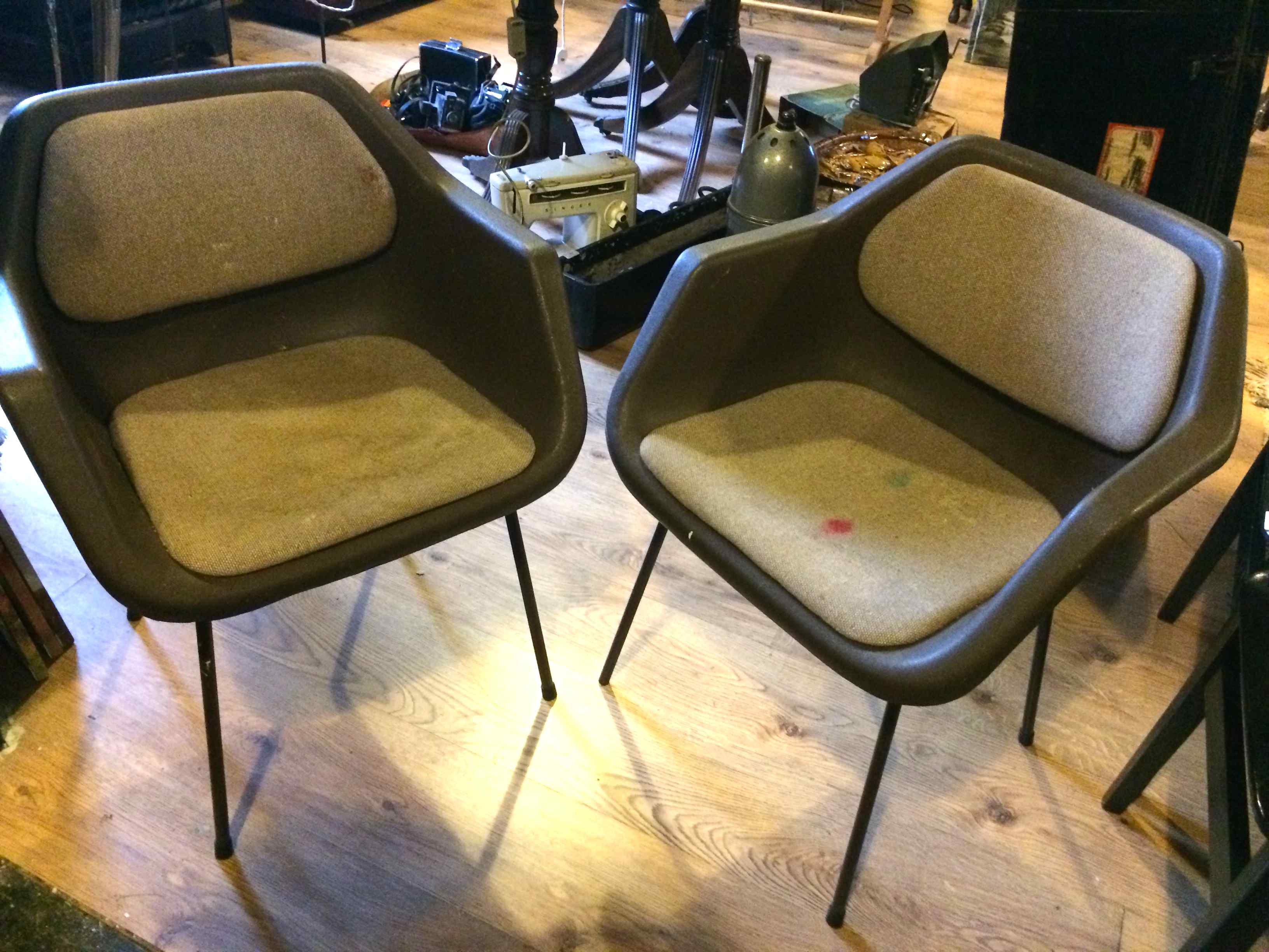 Pair of 20thC plastic chairs with detachable seats and pads, with metal legs.