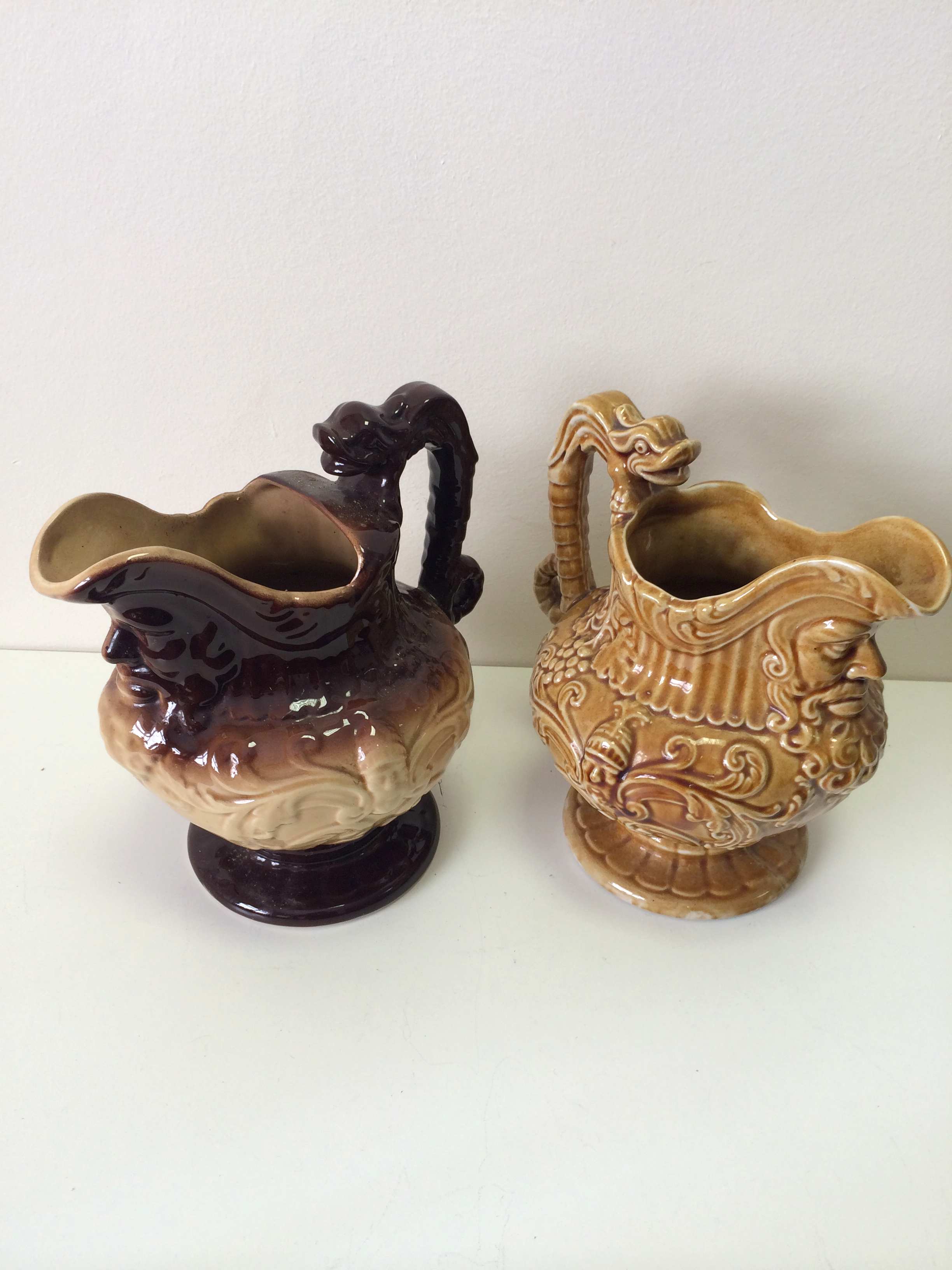 Two highly decorative majolica jugs, with bearded face decoration under the lip, in brown and ocre