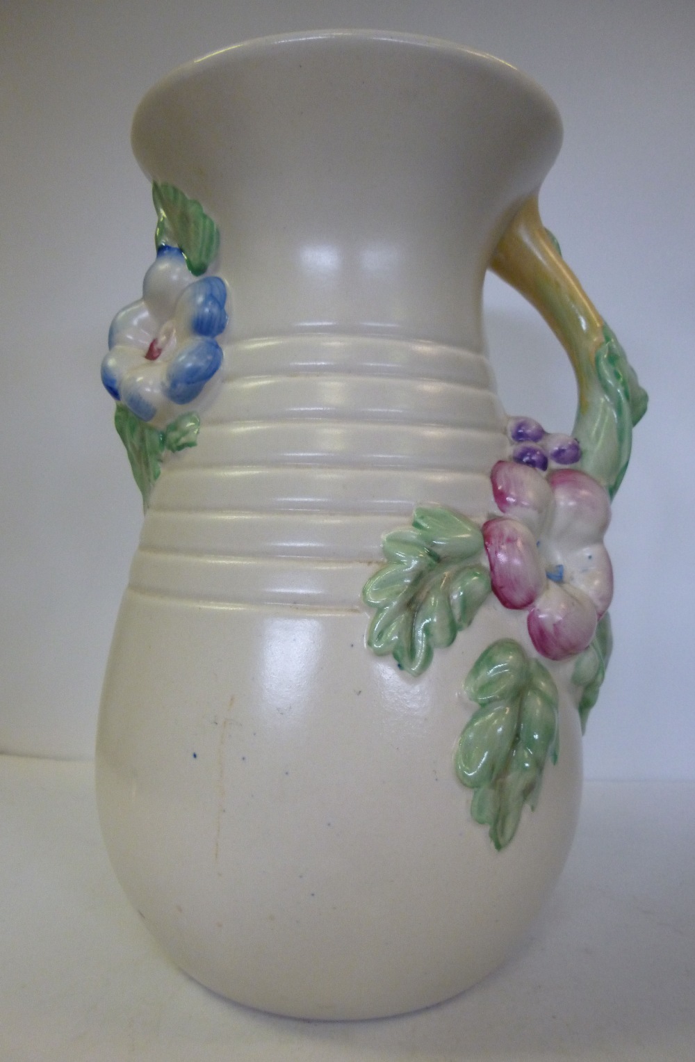 A Clarice Cliff pottery vase of ovoid form, having a flared rim and a naturalistically moulded and