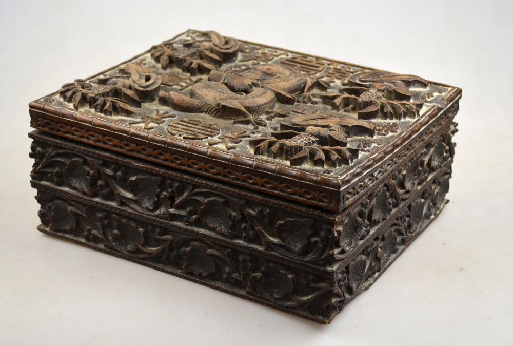 A Chinese hardwood box carved with birds surrounding a writhing dragon on a shou carved ground, 19th