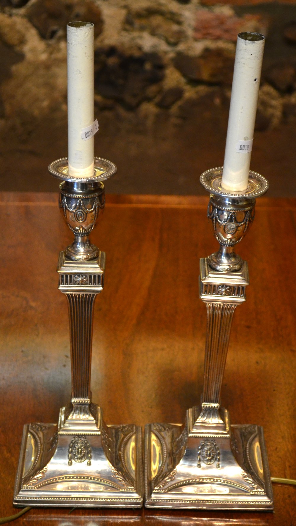 A pair of electroplated neo-classical-style candlestick lamps with fluted pillars and square