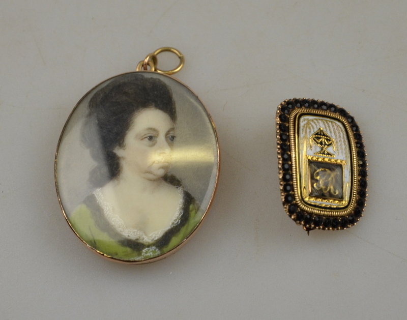 A small rectangular Georgian mourning brooch having black and white enamel scene of an urn beneath a