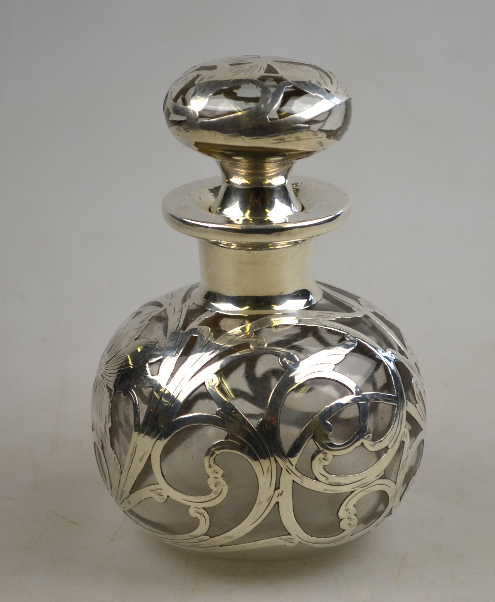 A globular glass scent bottle and stopper with floral and scrolling foliate white metal inlays, 13