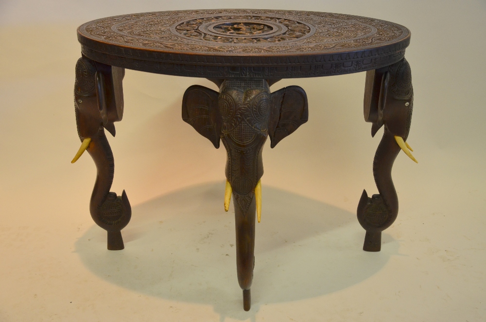 An Indian oval hardwood occasional table having a central circular cartouche carved with a