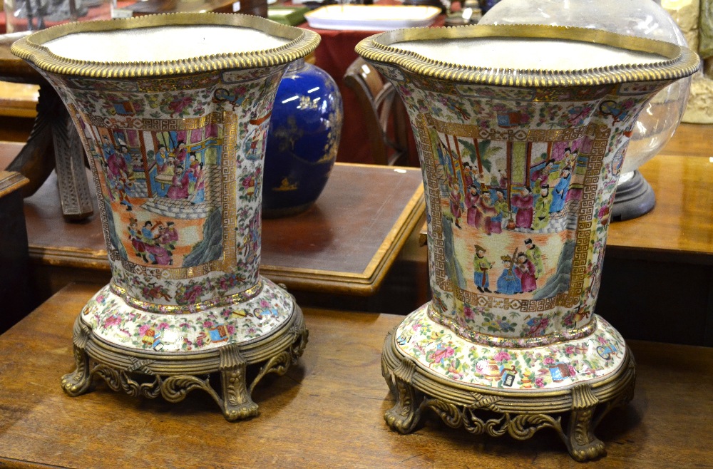 A pair of Chinese famille rose quatrefoil vases decorated with panels of figures in interiors