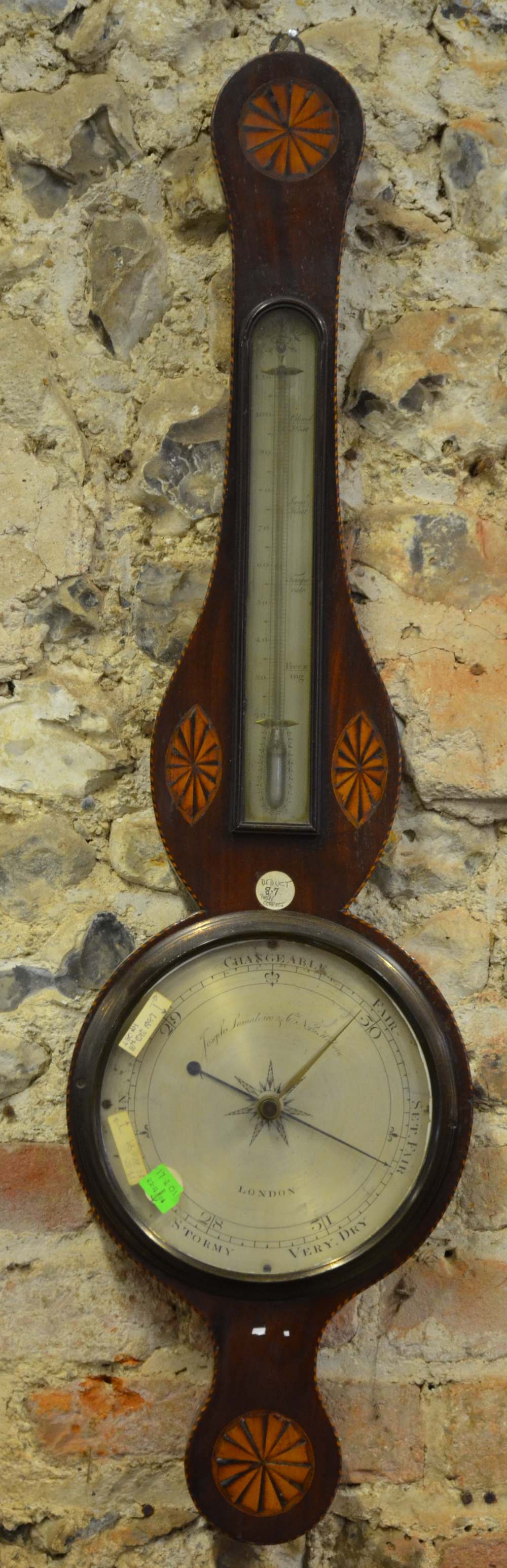 An inlaid mahogany wheel barometer, the mercury thermometer with silvered scale and with silvered
