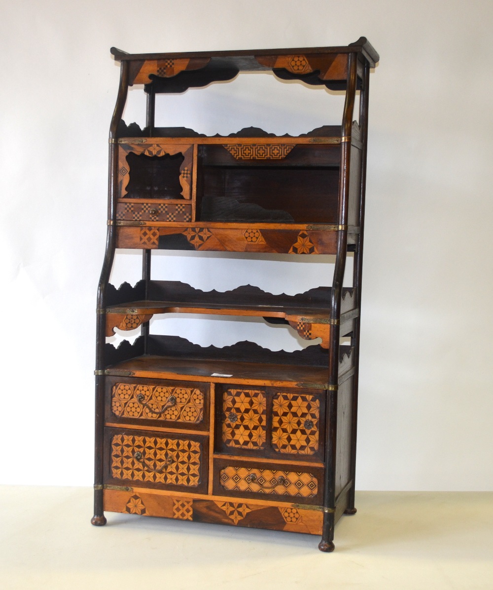 An Anglo-Japanese parquetry inlaid waterfall stand having graduated open tiers, niches, drawers and